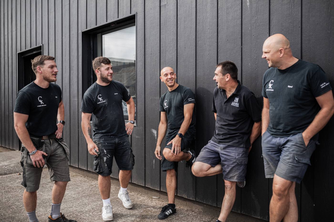Five Cymru Kitchens craftsmen in CK-branded shirts at the Turner Street workshop, Newport